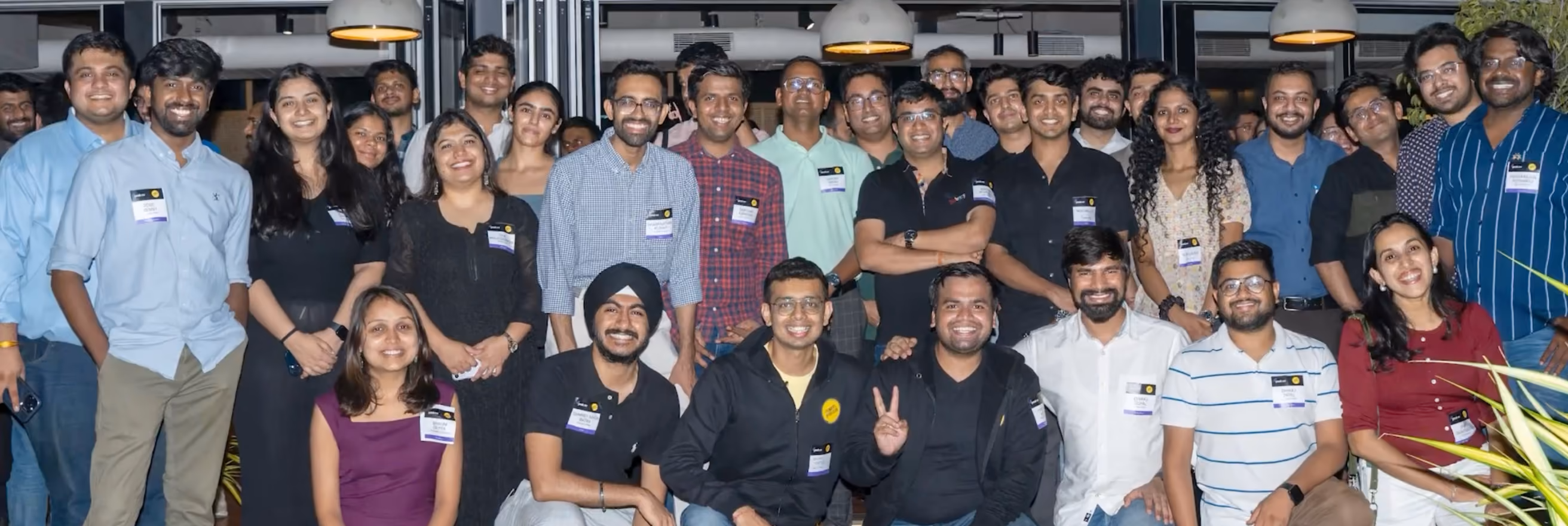 Group of diverse people smiling and posing indoors at a social or professional event.