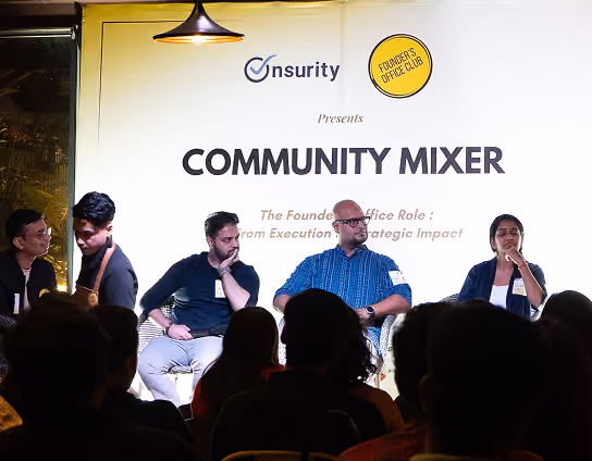 Panel of four speakers at a community mixer event with seated audience in the foreground.